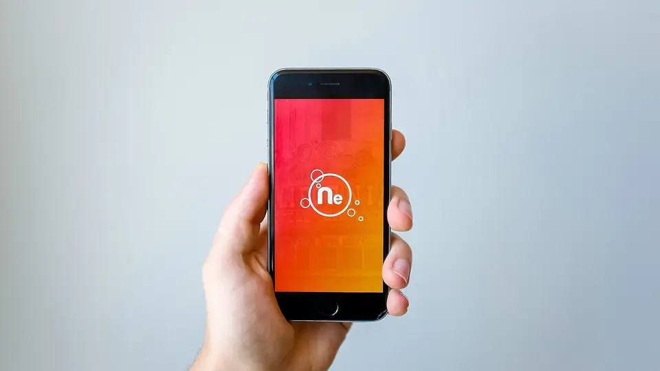 A hand holding a smartphone showing an app