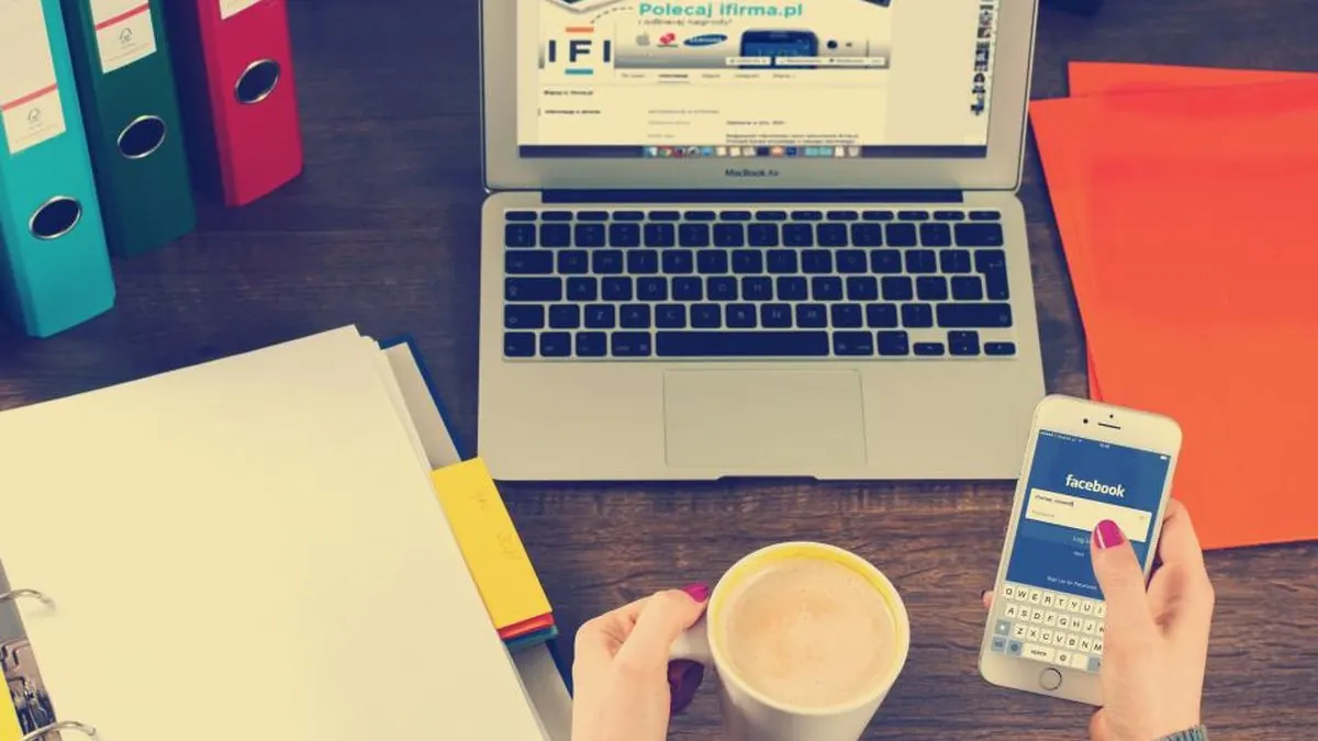 A phone and laptop on a desk with notes
