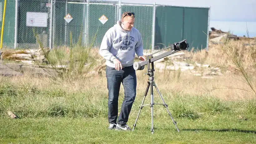A videographer filming with a camera on a tripod